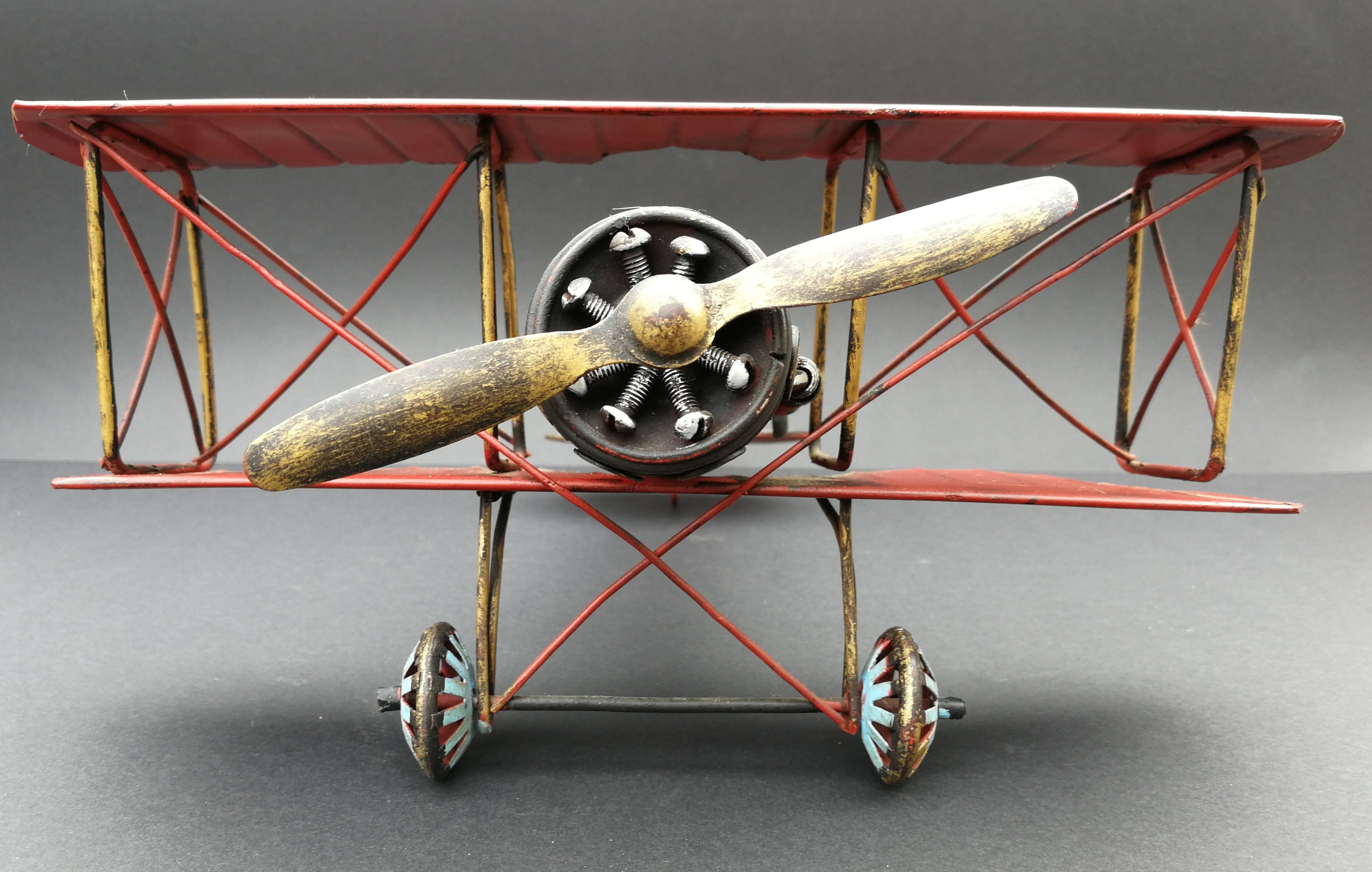 Tin aeroplane. Red and black. Hand made. Front view.