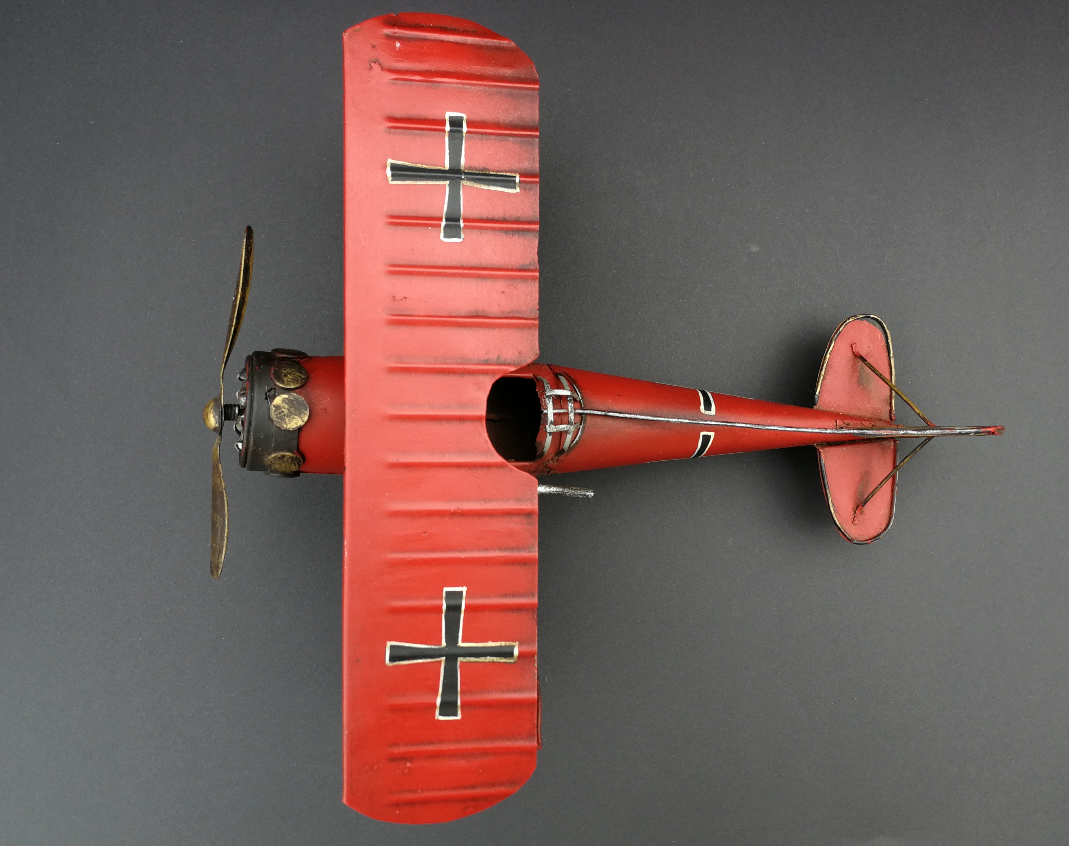 Tin aeroplane. Red and black. Hand made. View from top.