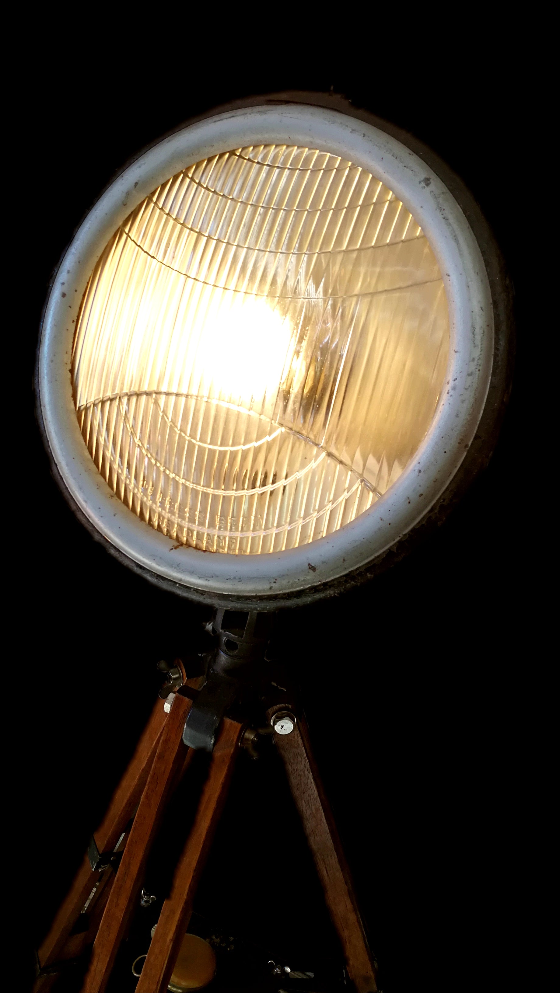Re-purposed dumpy level tripod lamp close up view of light